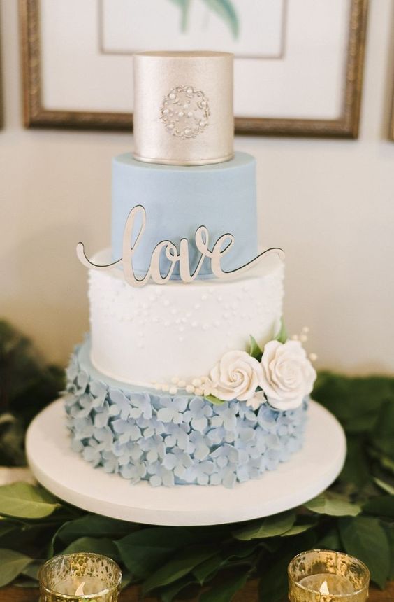 a vintage wedding cake with a gold, a serenity blue and a textural white tier, with sugar blooms and gold calligraphy for a vintage wedding
