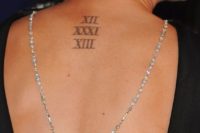 a wedding date tattoo made with Roman numbers on the back and accented with a necklace by Kaley Cuoco