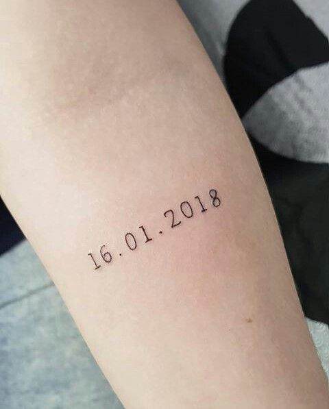 a wedding date tattoo made with usual numbers and placed on the arm