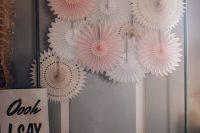 a wedding photo zone with white and blush paper fans and matching paper balls on the floor is amazing