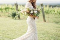 a white lace sheath wedding dress with a high neckline, short sleeves and a long train looks spectacular