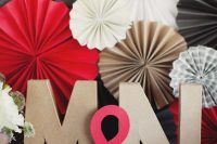 bright wedding decor with white, black and red paper fans of various sizes, with monograms and an ampersand is cool