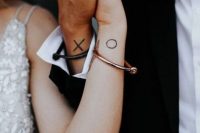 cute X O tattoos on the wrists are perfect for a modern couple, they are matching and stylish