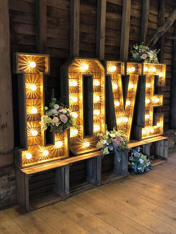 oversized rustic marquee LOVE letters decorated with greeneery and blooms can meet your guests at the entrance