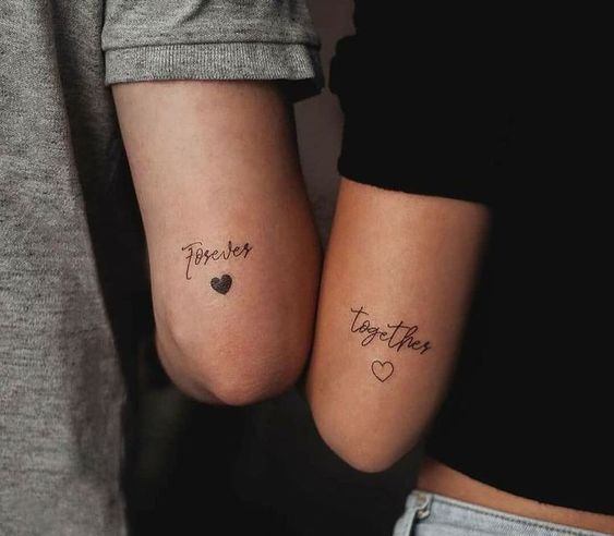 'together' tattoos with hearts placed on the arms are amazing not only for a couple but also for friends