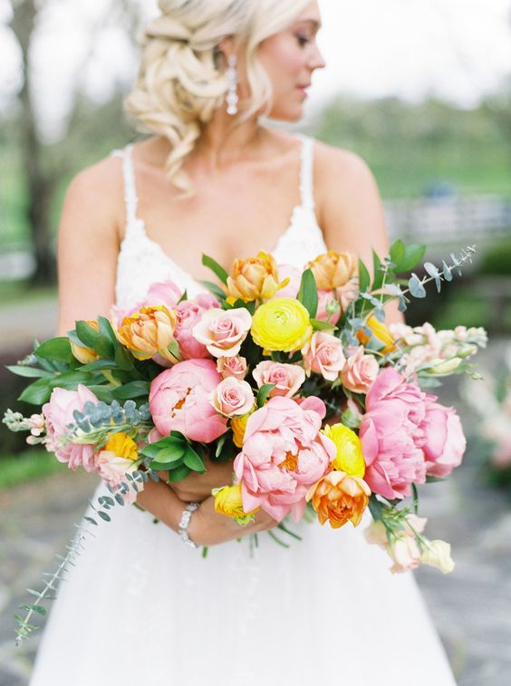 a beautiful and fresh spring wedding bouquet of pink peonies and yellow ranunculus plus eucalyptus is amazing