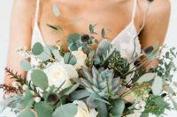 a beautiful and textural wedding bouquet of greenery, succulents, white roses and thistles plus some fillers is ultimate