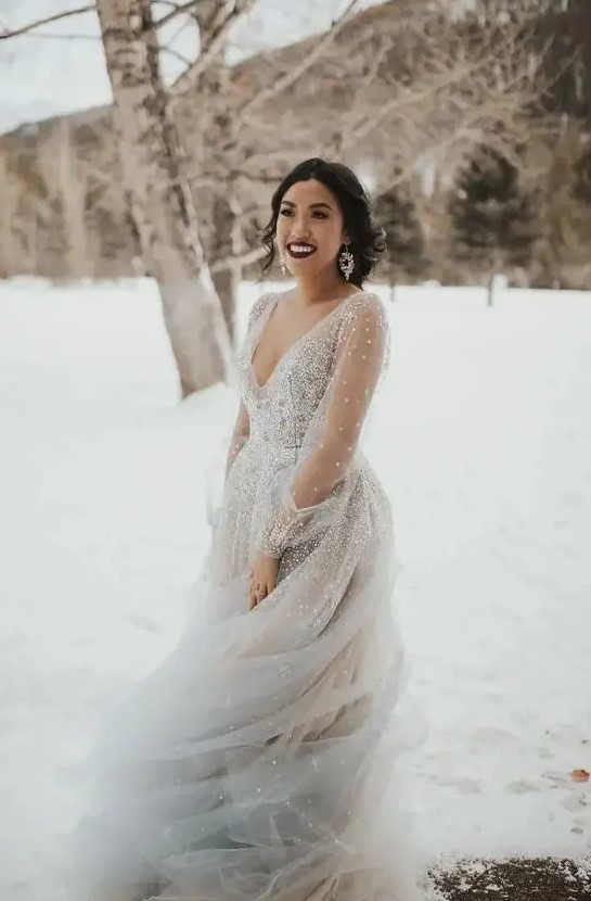 a beautiful grey fully embellished wedding ballgown with a deep V neckline and sheer sleeves for a real ice queen
