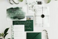 a beautiful wedding invitation suite with hunter green envelopes, white invites with leaves painted and a watercolor calligraphy piece