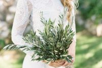 a beautiful white lace wedding dress with a high neckline, statement earrings and an olive branch wedding bouquet for an Italy-themed wedding
