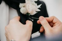 a blush rose and white dried leaves and blooms boutonniere is a chic and refined idea for a modern groom