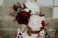 a bold wedding cake with gold leaf, polka dots, a handpainted floral tier and lush fresh flowers plus a calligraphy topper