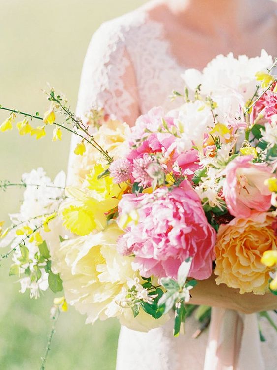 a bright wedding bouquet with pink peonies, yellow and white blooms and foliage is amazing for a spring or summer wedding