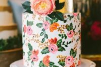 a bright wedding cake with a gold foil tier and a colorful floral one in pink and orange with a real bloom on top