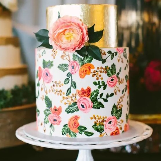 a bright wedding cake with a gold foil tier and a colorful floral one in pink and orange with a real bloom on top