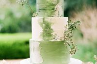 a brushstroke white and green wedding cake with greenery branches is a pretty idea for a spring wedding