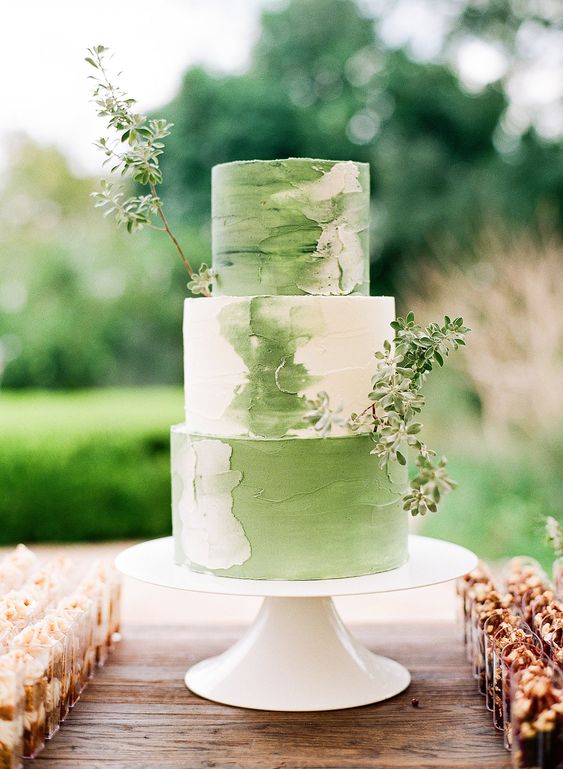 a brushstroke white and green wedding cake with greenery branches is a pretty idea for a spring wedding