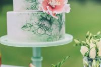 a chic handpainted wedding cake in green and white decorated with a single pink sugar bloom