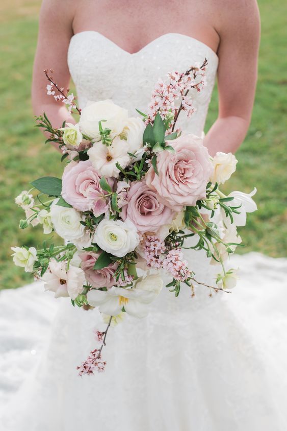 a chic pink and white spring wedding bouquet with blooming cherry branches and greenery