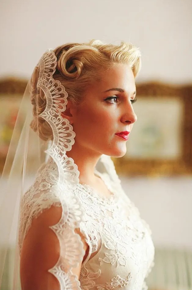 a classic curled updo with a mantilla veil with a lace edge are a great combo for a chic and refined classic bridal look