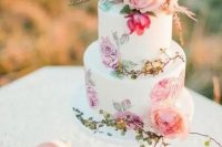 a colorful handpainted wedding cake with pink and lilac blooms and fresh blooms on top is amazing for summer