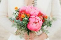 a colorful spring wedding bouquet with bright pink peonies, pincushion proteas and several types of eucalyptus