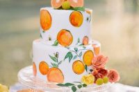 a creative hand painted wedding cake with citrus and greenery and with citrus on top is a gorgeous idea, add some bright blooms and go