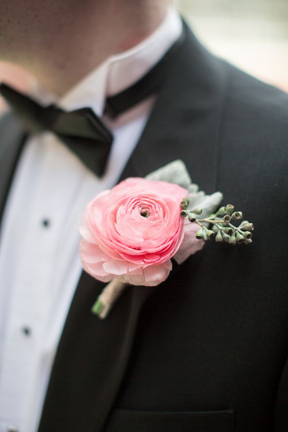a delicate and chic pink ranunculus and greenery boutonniere is a delicate and sutble touch of color to your outfit