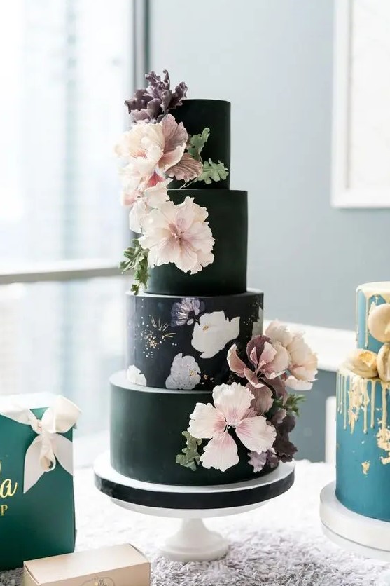 a dramatic wedding cake with several black tiers and a single floral one, sugar blooms for decor that match hand painting
