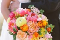 a fab bold wedding bouquet of pink, peachy, yellow and lemon yellow blooms and greenery for a colorful wedding