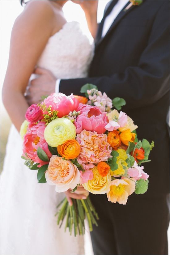 a fab bold wedding bouquet of pink, peachy, yellow and lemon yellow blooms and greenery for a colorful wedding