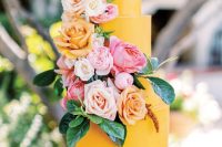 a fab yellow buttercream wedding cake decorated with blush, pink and yellow roses and leaves for a summer or fall wedding