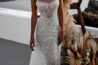 a fabulous fully beaded semi sheer fitting wedding dress with a corset-like top and thick straps plus a train is amazing