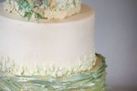 a fabulous wedding cake with white and green tiers, with touches og gold and sugar blooms and leaves is a masterpiece
