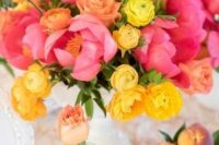 a fantastic wedding centerpiece of pink peonies and yellow ranunculus is a gorgeous color statement for your table