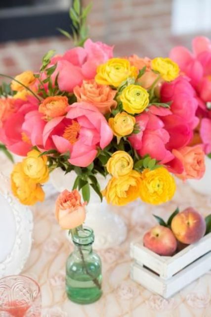 a fantastic wedding centerpiece of pink peonies and yellow ranunculus is a gorgeous color statement for your table