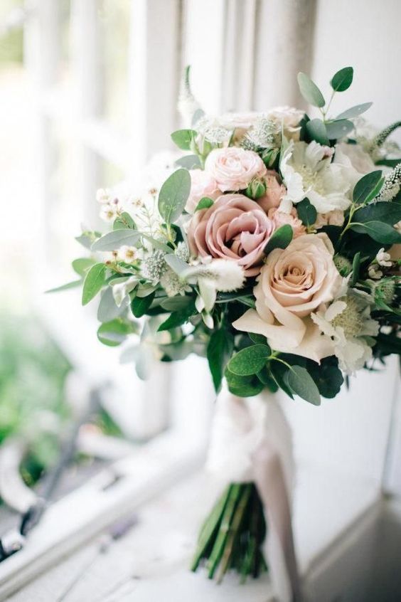 a fresh spring wedding bouquet with pink and white blooms and greenery and much texture