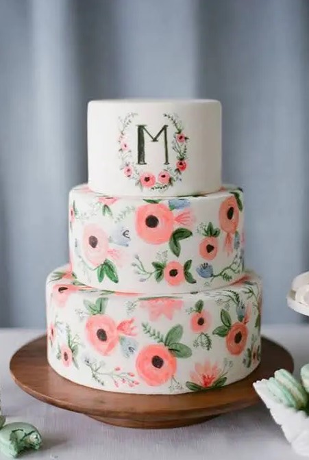 a fun handpainted wedding cake in bold coral with a primitivist touch, a large monogram on the top tier