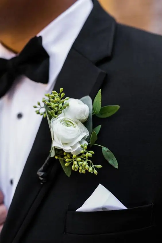 a lovely modern wedding boutonniere of white ranunculus and seeded euclayptus is a fresh touch to a chic modern groom's look