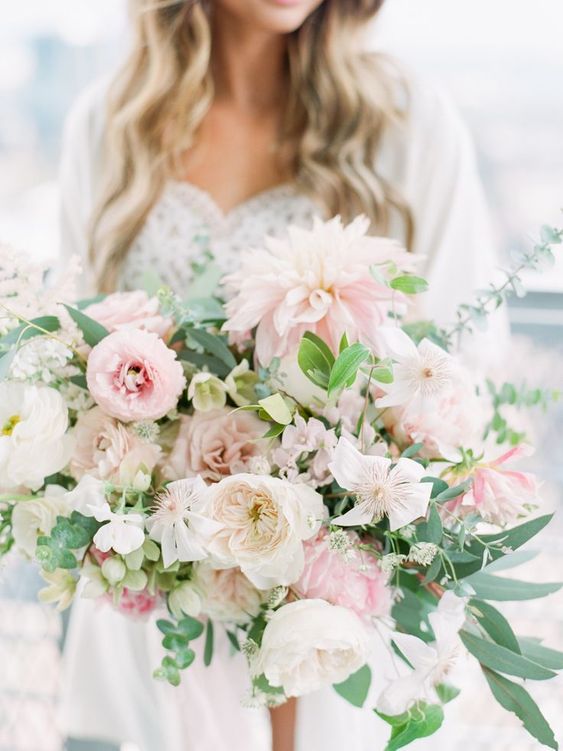 a lush and romantic pink wedding bouquet with greenery, with plenty of texture and a catchy shape
