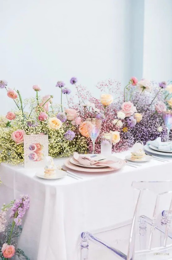 a modern and bright secret garden wedding table setting with a color block baby's breath and rose runner, pastel place settings is amazing