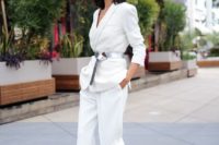 a modern white pantsuit with a deep neckline, a metallic belt and nude shoes for an edgy outfit