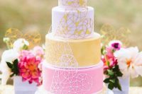 a pretty geometric wedding cake with white, yellow and pink tiers and geometric hearts on each tier for a bolder look