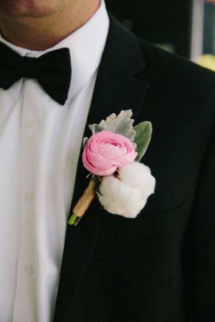 a pretty modern wedding boutonniere with a pink ranunculus, a cotton piece and pale leaves is a beautiful idea for a modern exquisite wedding
