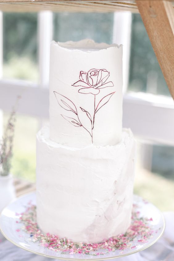 a refined minimalist wedding cake with a raw edge, a hand painted flower and dusty pink brushstrokes is amazing for spring
