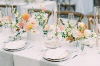 a refined neutral spring wedding tablescape with peachy and orange blooms, grey and white linens feels fresh