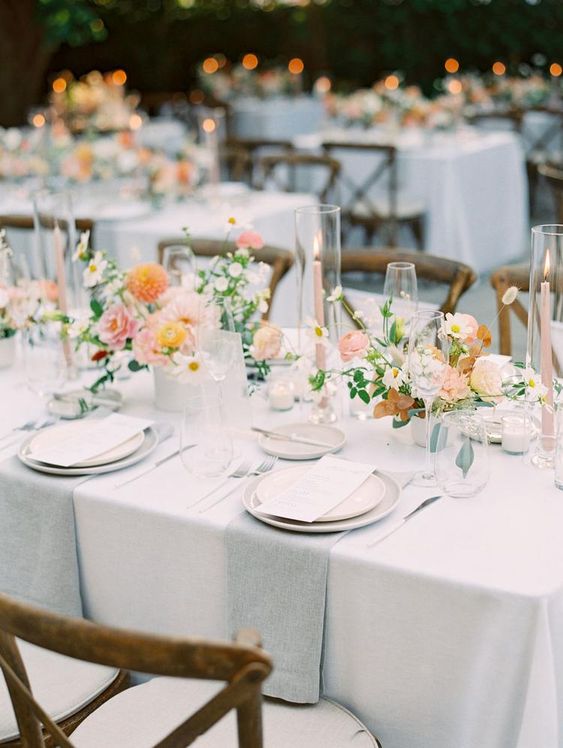 a refined neutral spring wedding tablescape with peachy and orange blooms, grey and white linens feels fresh