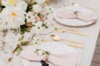 a refined spring wedding table setting with pink napkins, white blooms, blackberries and gold cutlery looks beautiful