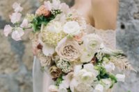 a romantic textural wedding bouque with blush and white blooms and some greenery