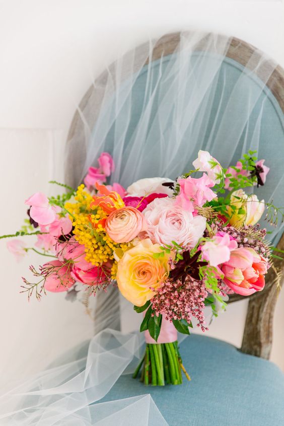 a romantic wedding bouquet of light and bol pink, yellow blooms, deep purple touches and berries is amazing